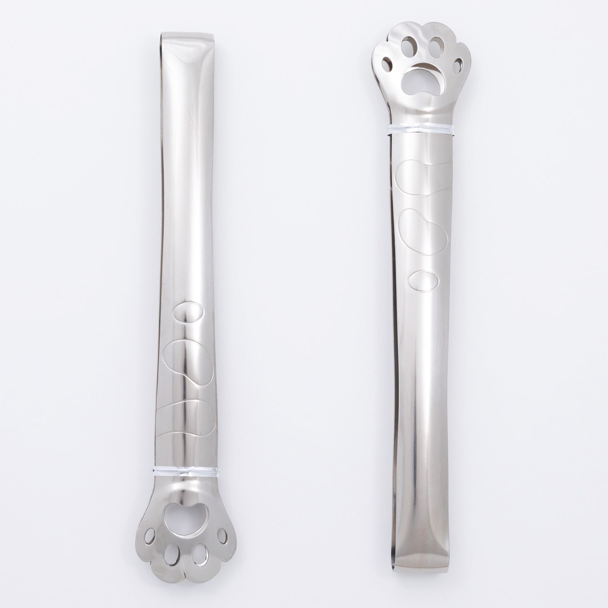 Two stainless steel paw print tongs on a white background