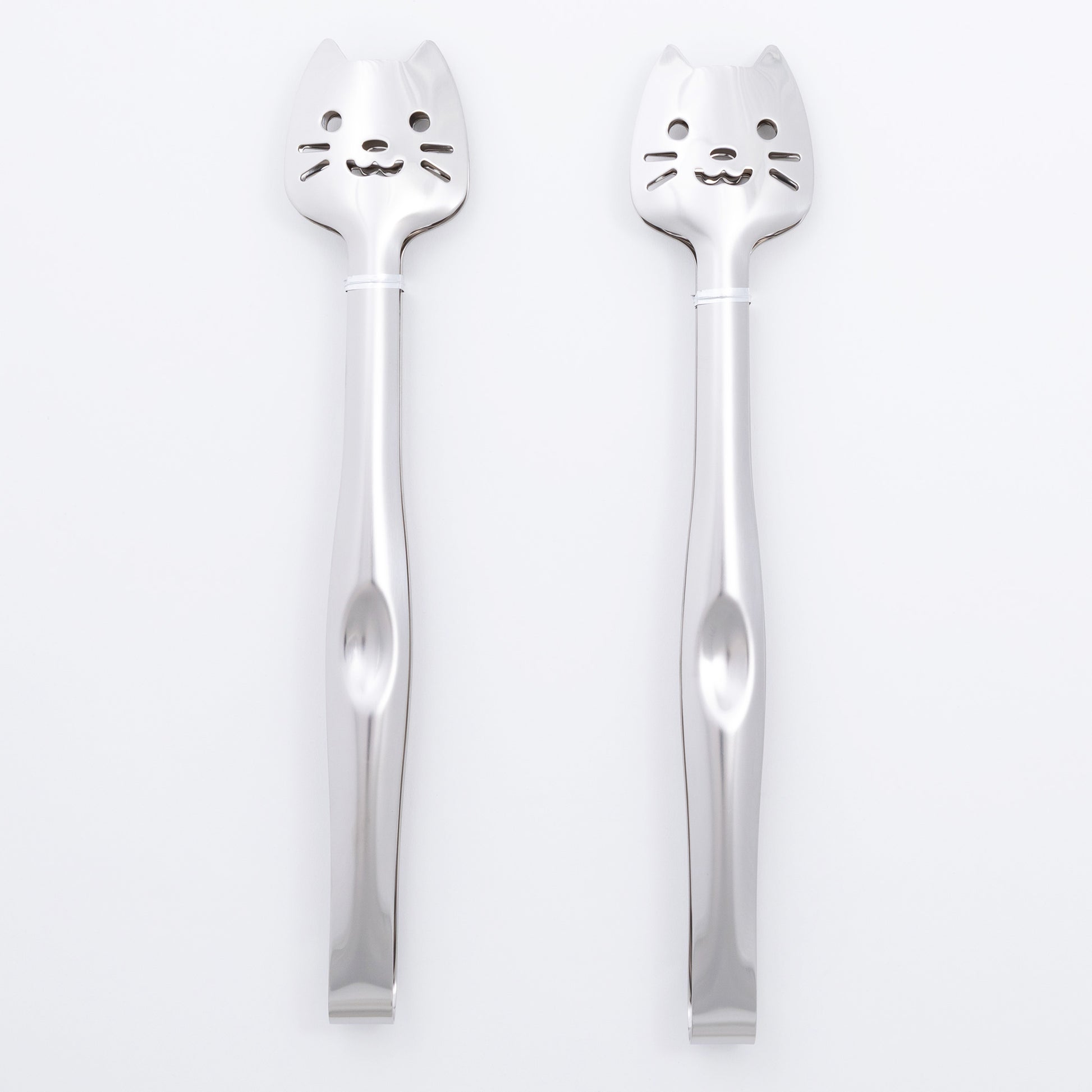 Two silver spoons with cat faces on a white background
