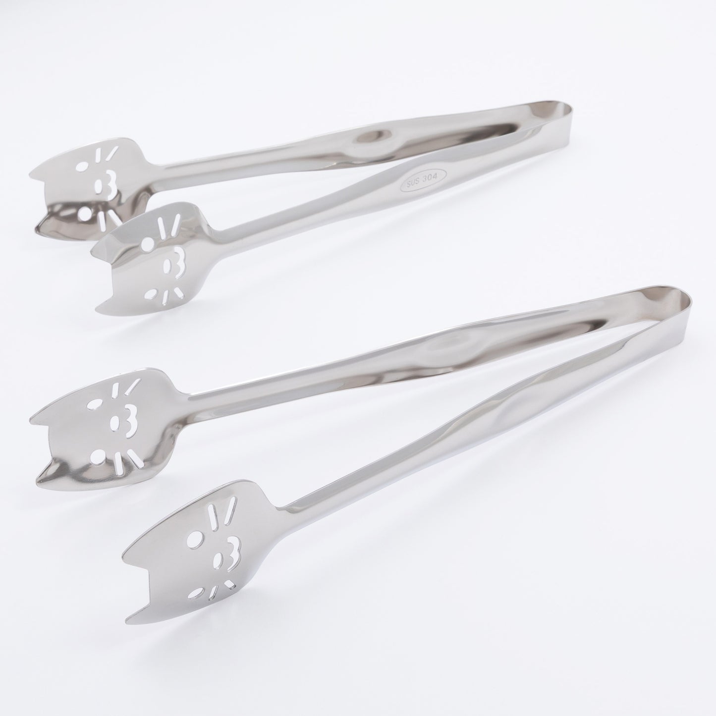 Set of two metal tongs with cat faces on a white background