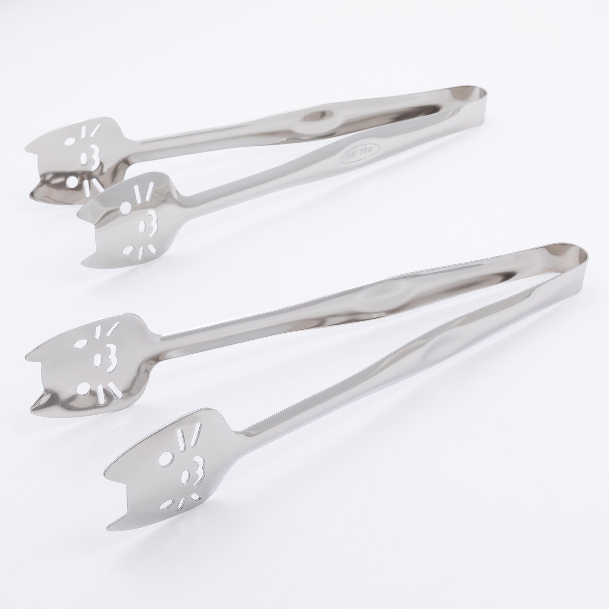 Set of two metal tongs with cat faces on a white background