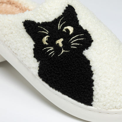 White slipper with a black cat design on a white background