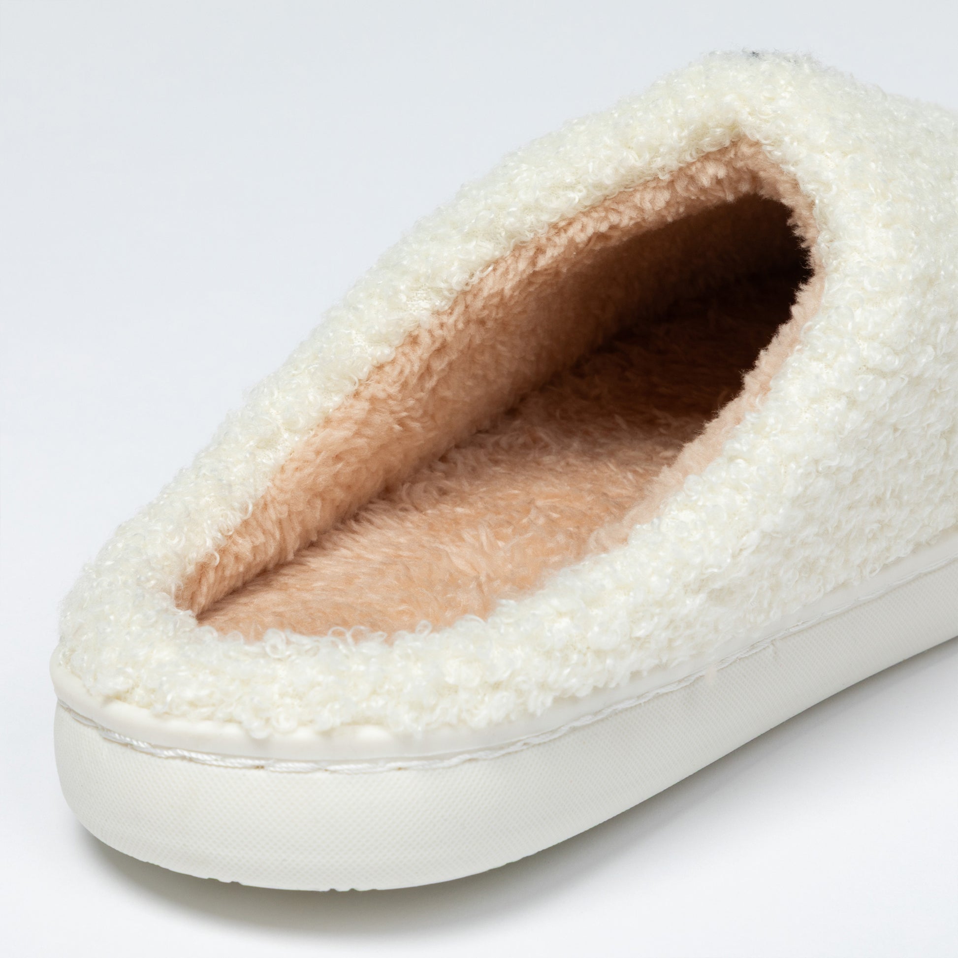 White slipper with fluffy interior on a light gray background