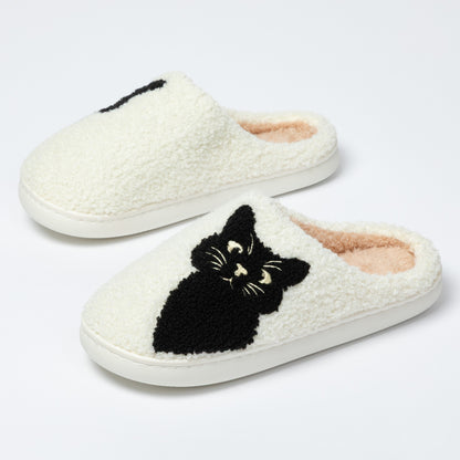 White slippers with black cat design on a white background