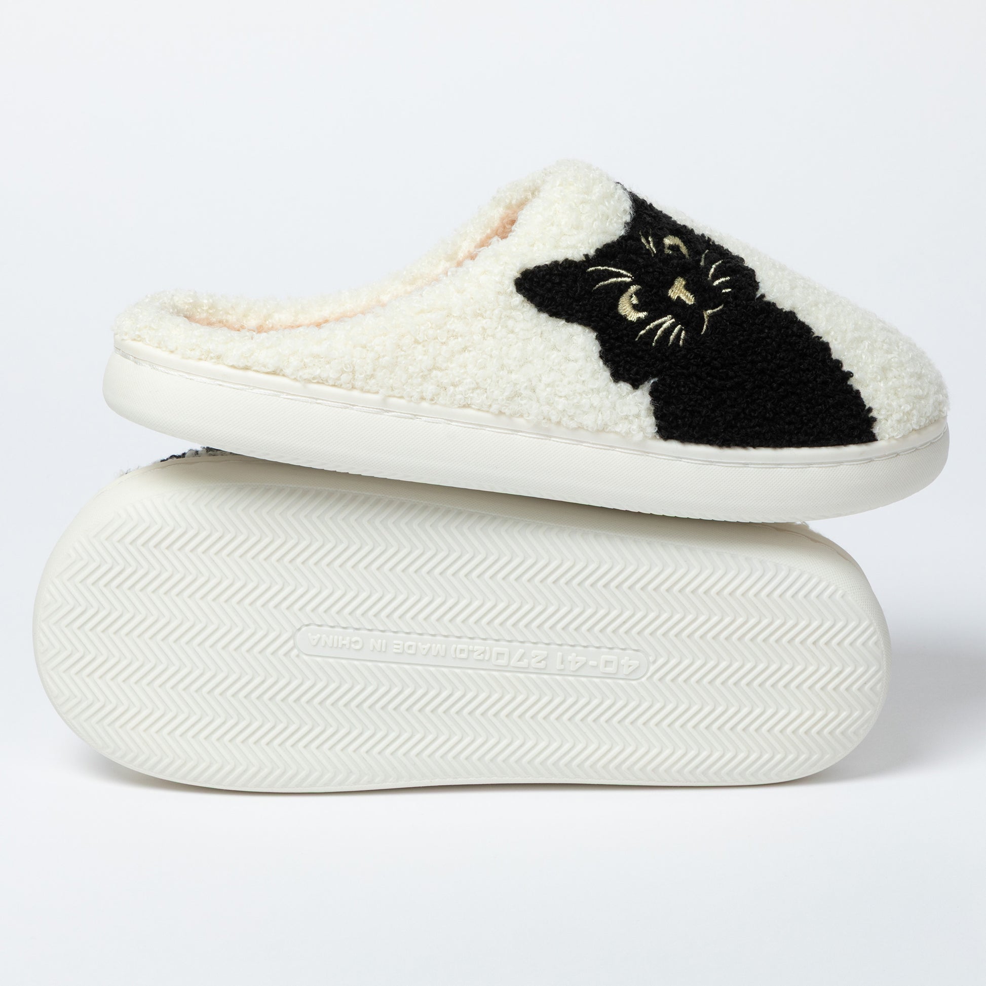 White slipper with black cat design on a white background