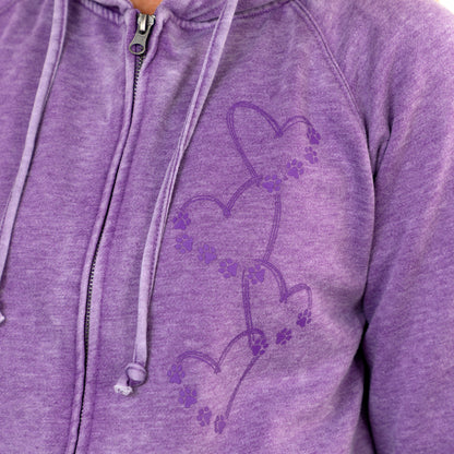 Close-up of a heather purple zip-up hoodie with a tonal purple graphic of connected hearts and paw prints on the chest.