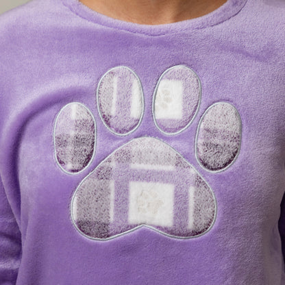 A close-up of a purple fleece pj top featuring a large paw print graphic on the front, worn by a person whose neck is visible at the top.