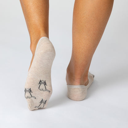 Beige socks with cat designs worn by a person on a light gray background