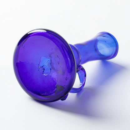 A translucent cobalt blue glass vase, photographed on a clean white background with a soft shadow.