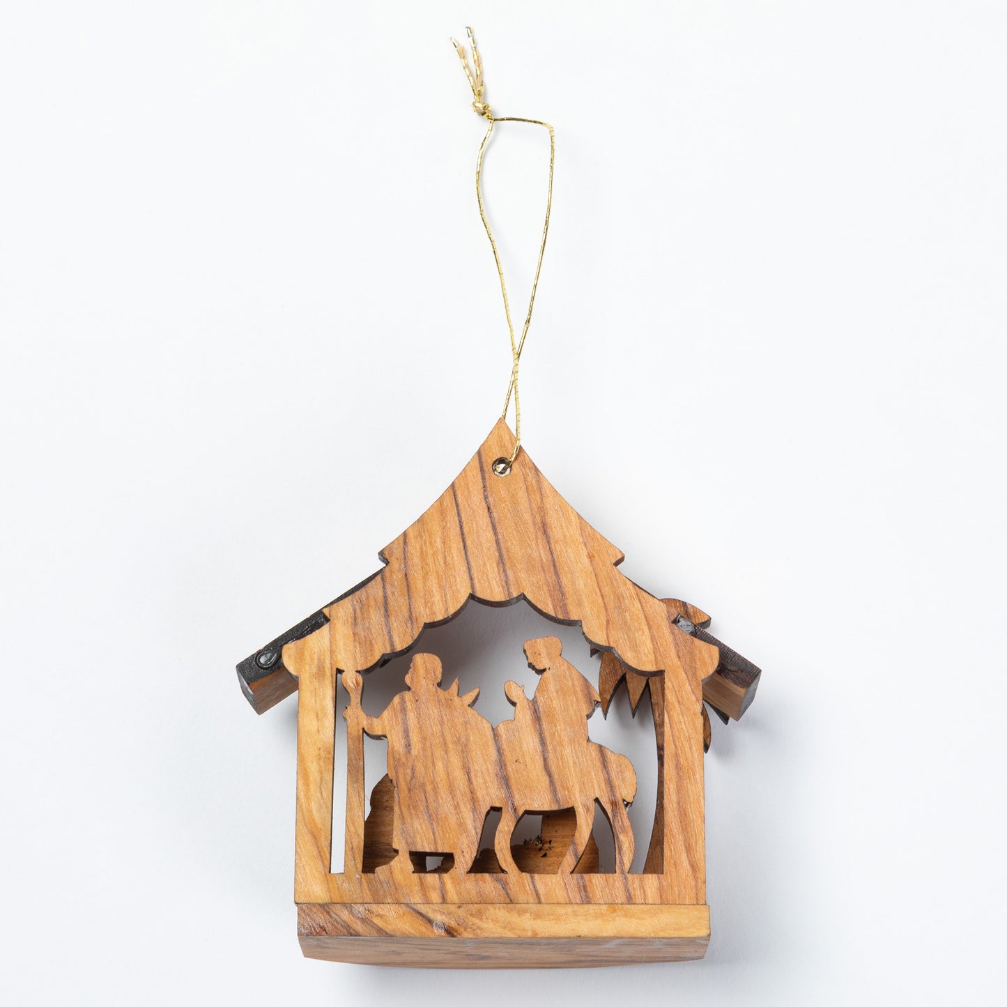 A small wooden hanging nativity ornament with a house-shaped frame and cutout figures, suspended by a thin string on a plain white background.