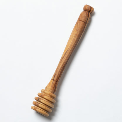 A handmade wooden honey dipper shown against a plain white background.