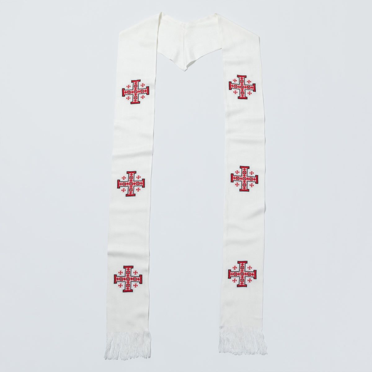 An off-white woolen liturgical stole with embroidered red and blue crosses, laid flat against a light gray background.