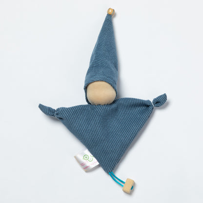 A blue ribbed fabric doll with a wooden pom-pom on the tip of the hat, a wooden pom-pom on the bottom corner, and a small white tag attached.