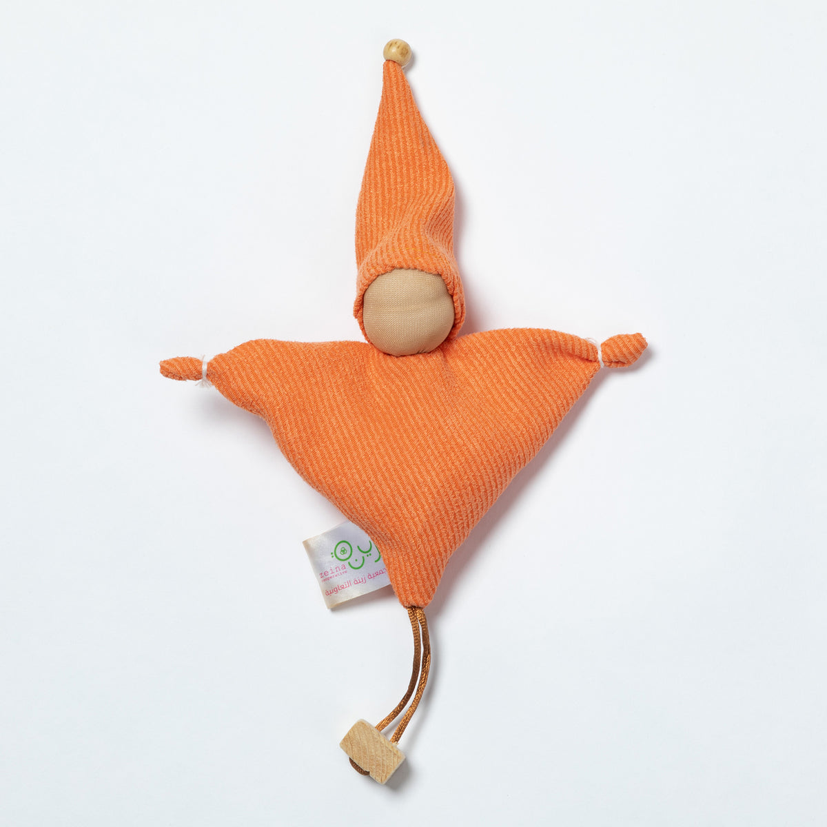 An orange textured fabric doll toy with a wooden head, pointed hat, and small tag, photographed on a clean white background.