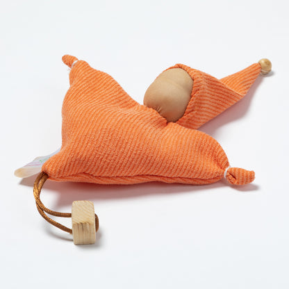 An orange ribbed fabric doll with a wooden pom-pom on the tip of the hat, a wooden pom-pom on the bottom corner, and a small white tag attached.