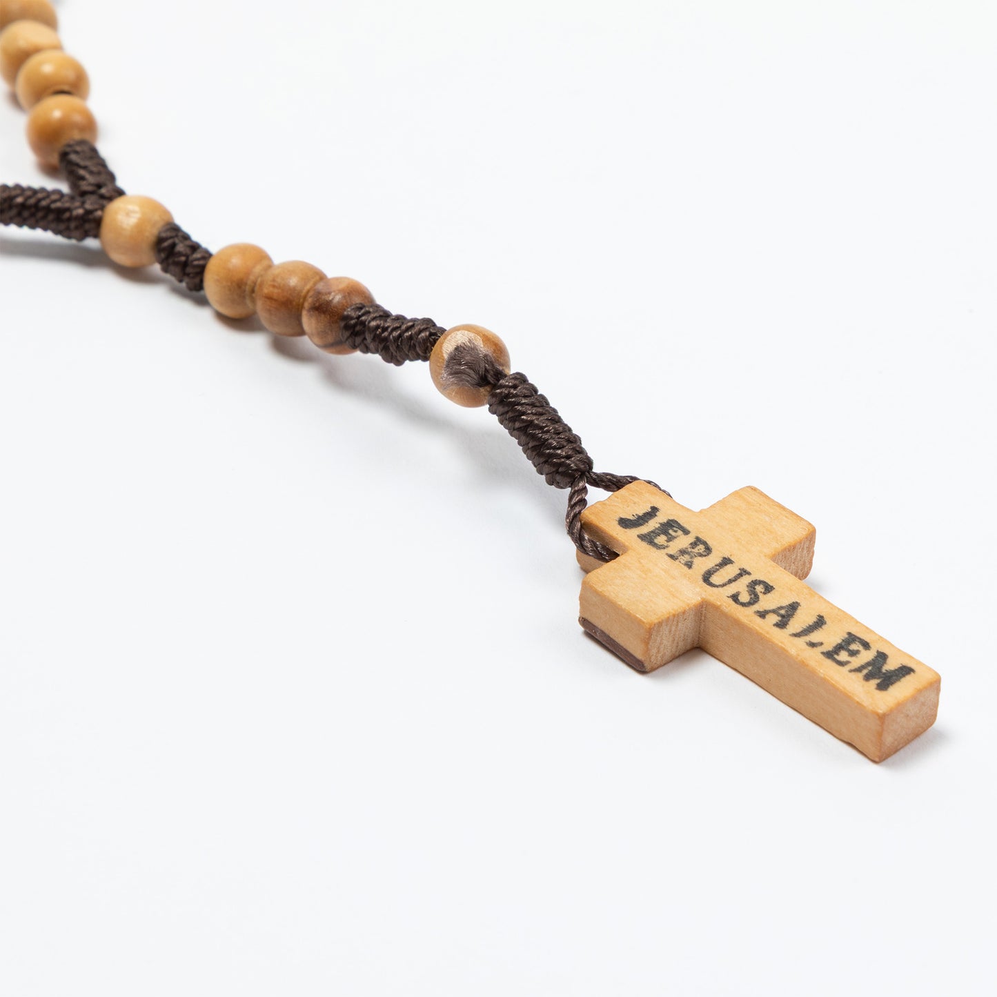 Wooden cross pendant with 'Jerusalem' engraving on a white background