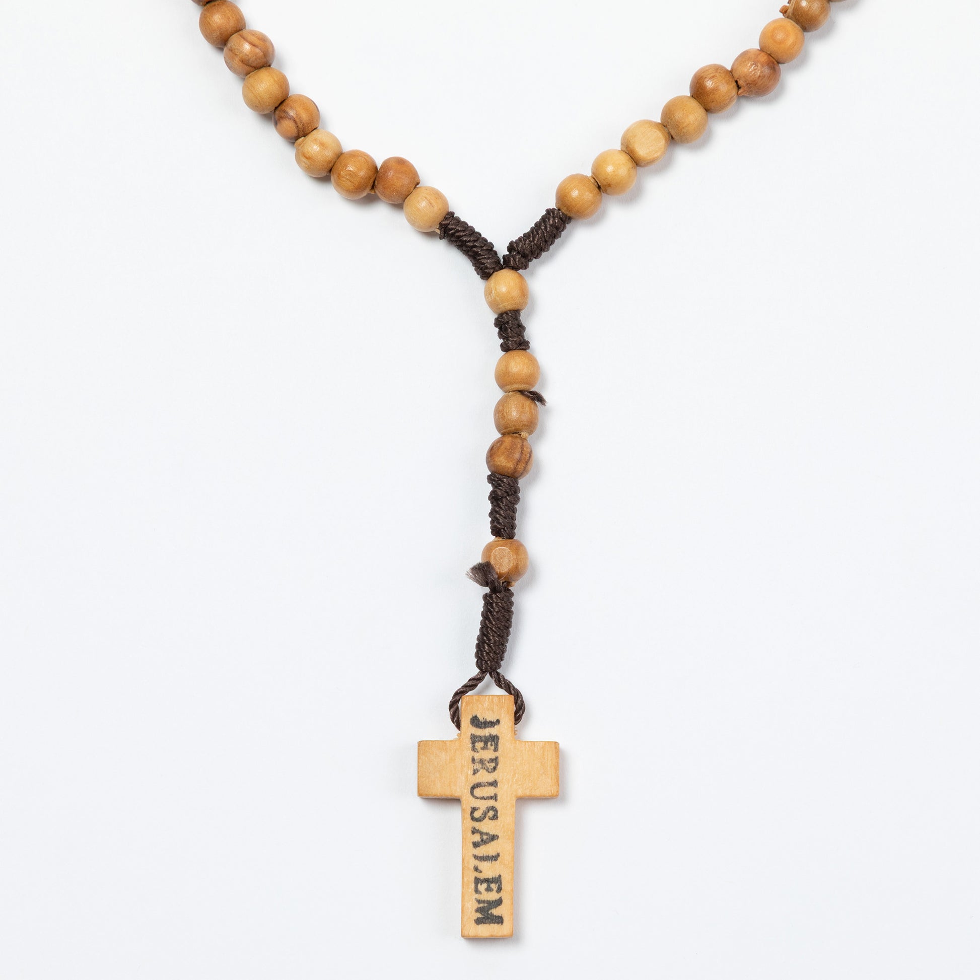 Wooden rosary with cross pendant on a white background