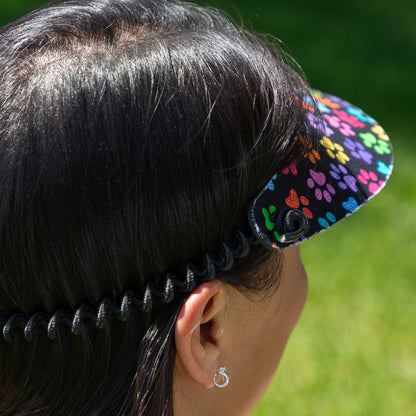 Person wearing a colorful visor with a blurred green background