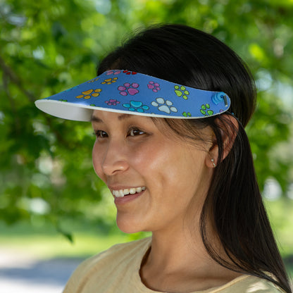 Woman wearing a colorful visor with paw prints outdoors
