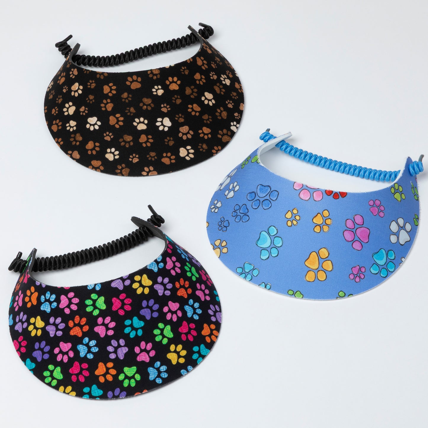 Three visors with paw print patterns on a white background