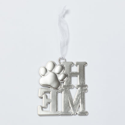 A silver metal pet memorial ornament featuring a paw print over the letters 'HOME', suspended from a white ribbon against a light gray background.