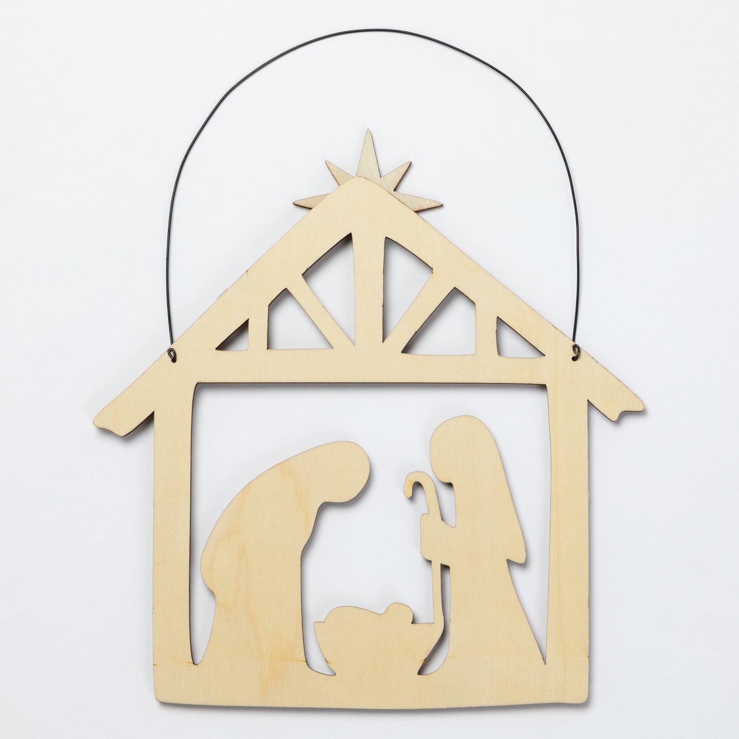 A light natural wood hanging nativity scene ornament with a black wire hanger, featuring silhouettes of Mary, Joseph, and baby Jesus under a star on a plain white background.