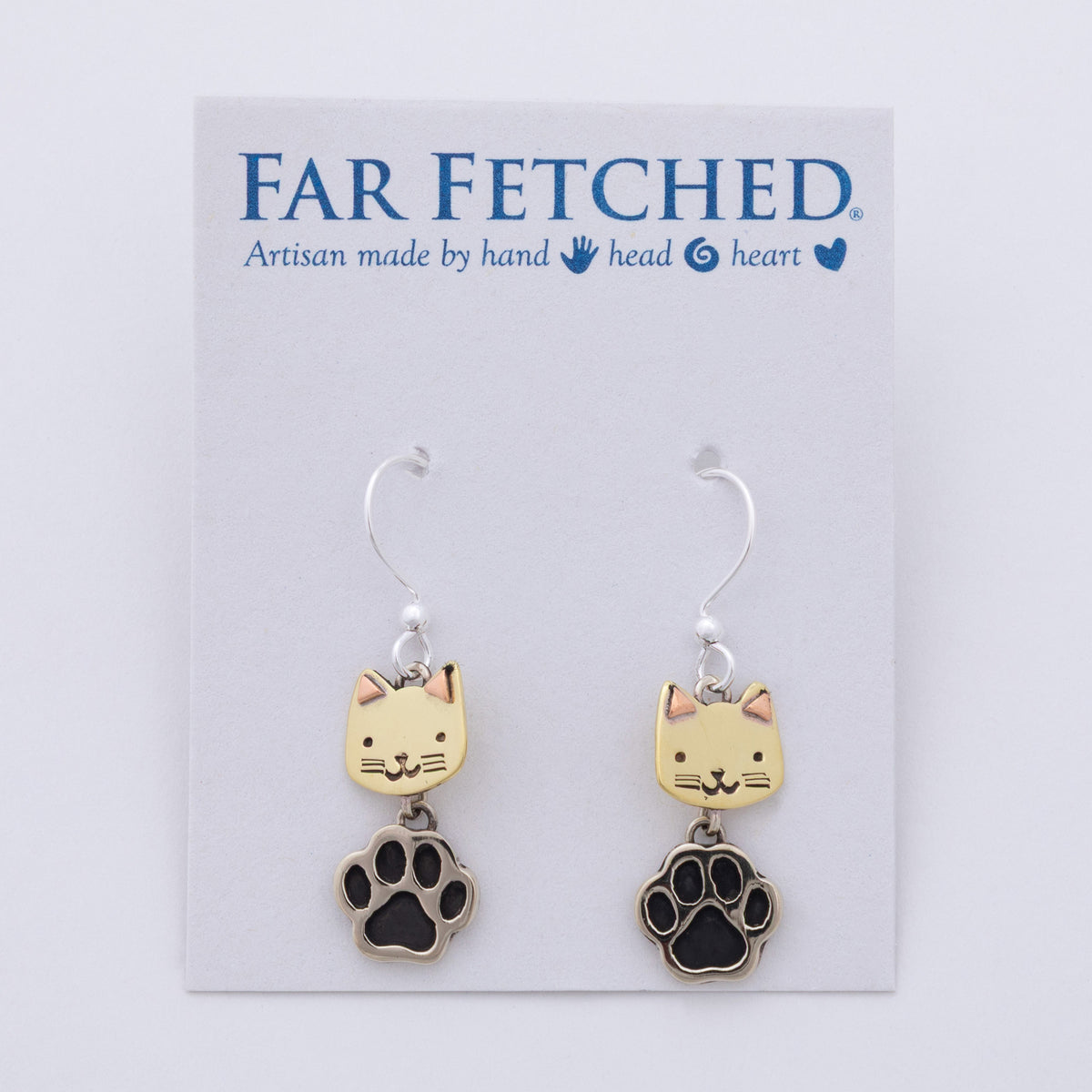 A pair of dangling earrings displayed on a white Far Fetched brand card. Each earring has a silver fishhook wire, a small pale yellow cat face charm, and a dangling black paw print charm outlined in silver.