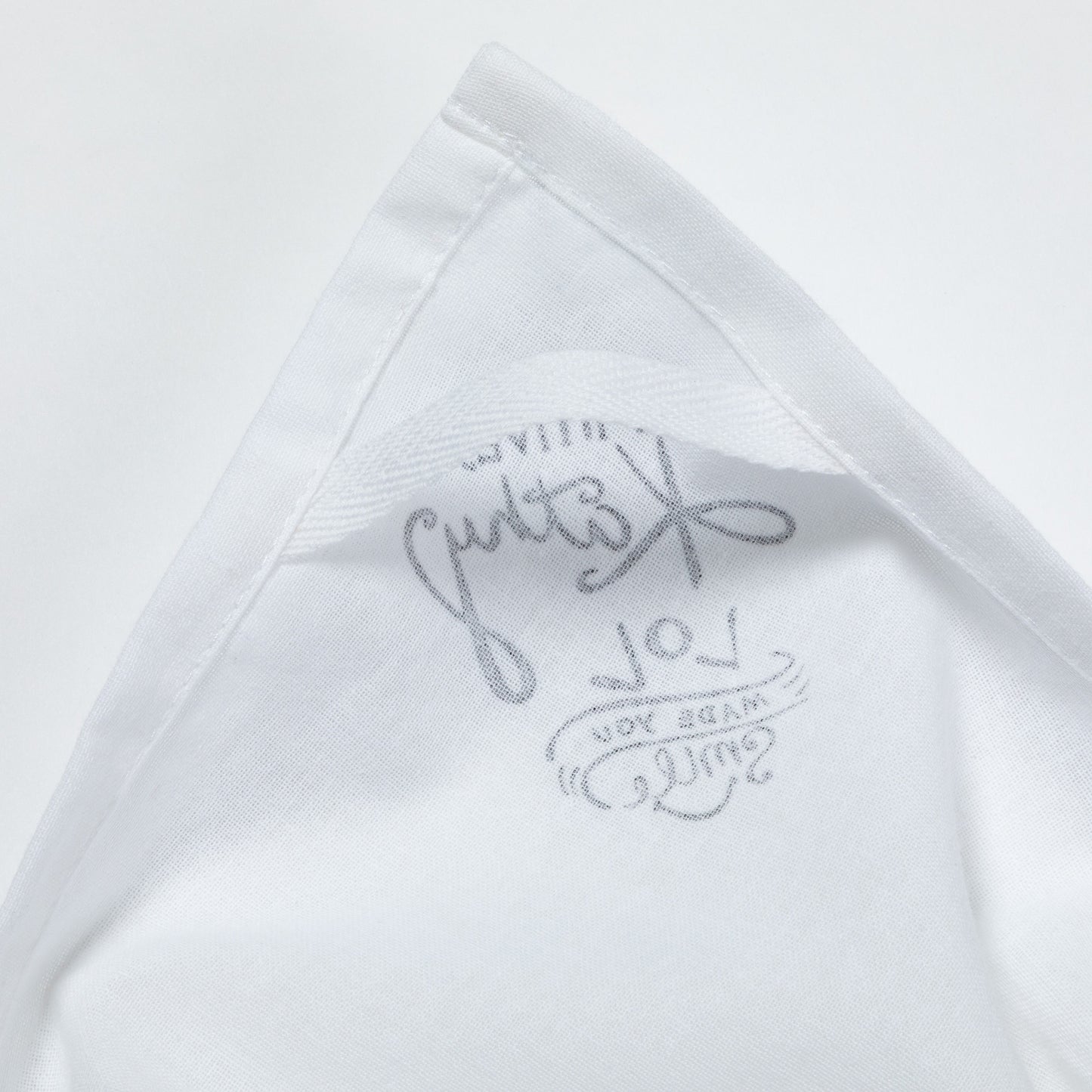 Close-up of a white dish towel with text on a light gray background