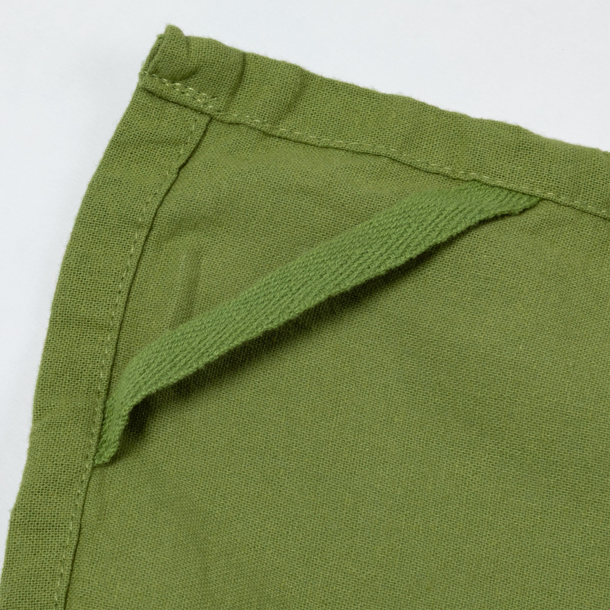 Close-up of green dish towel and loop with a white background