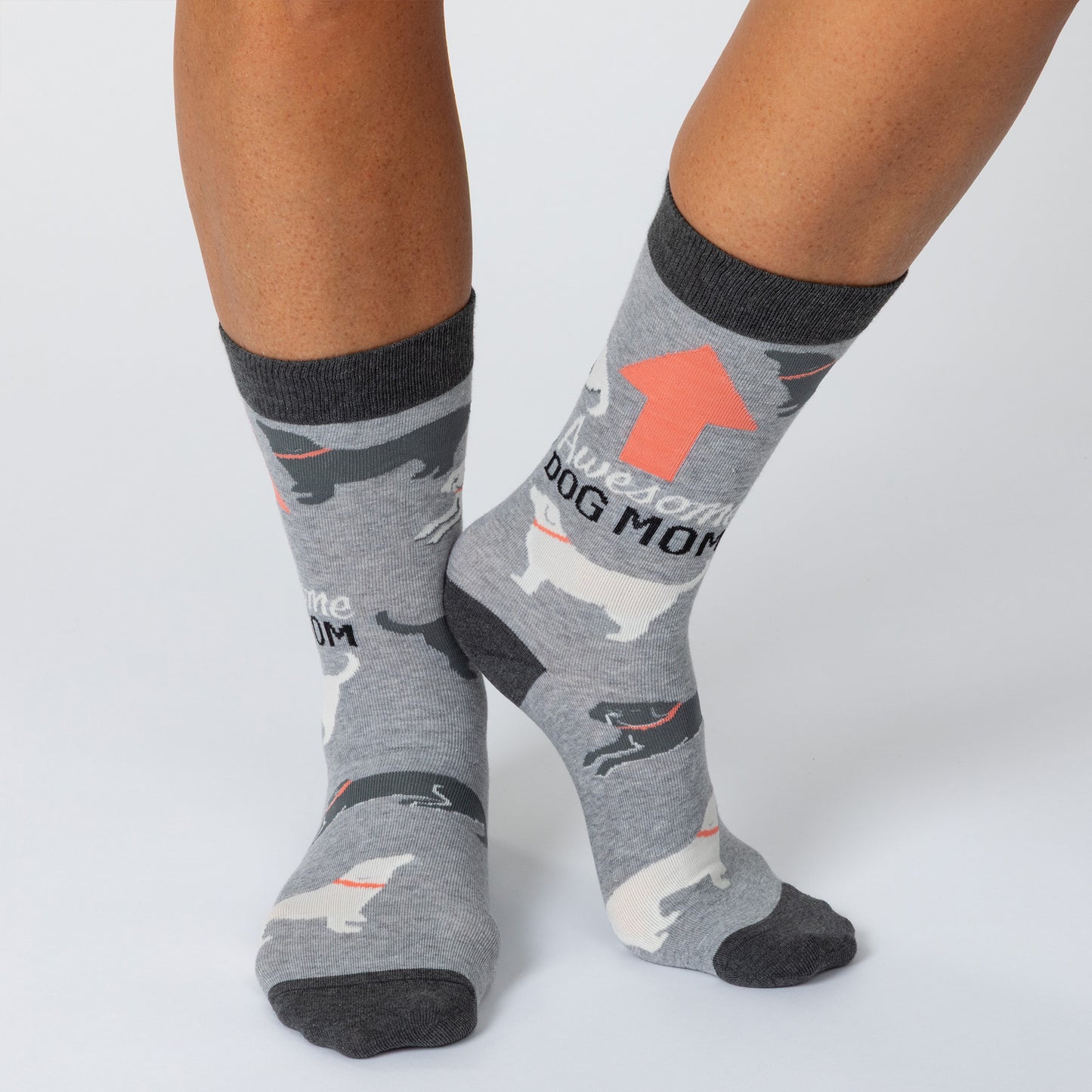 Feet wearing gray socks with dogs all over and the phrase "Awesome dog mom" with an arrow pointing up.
