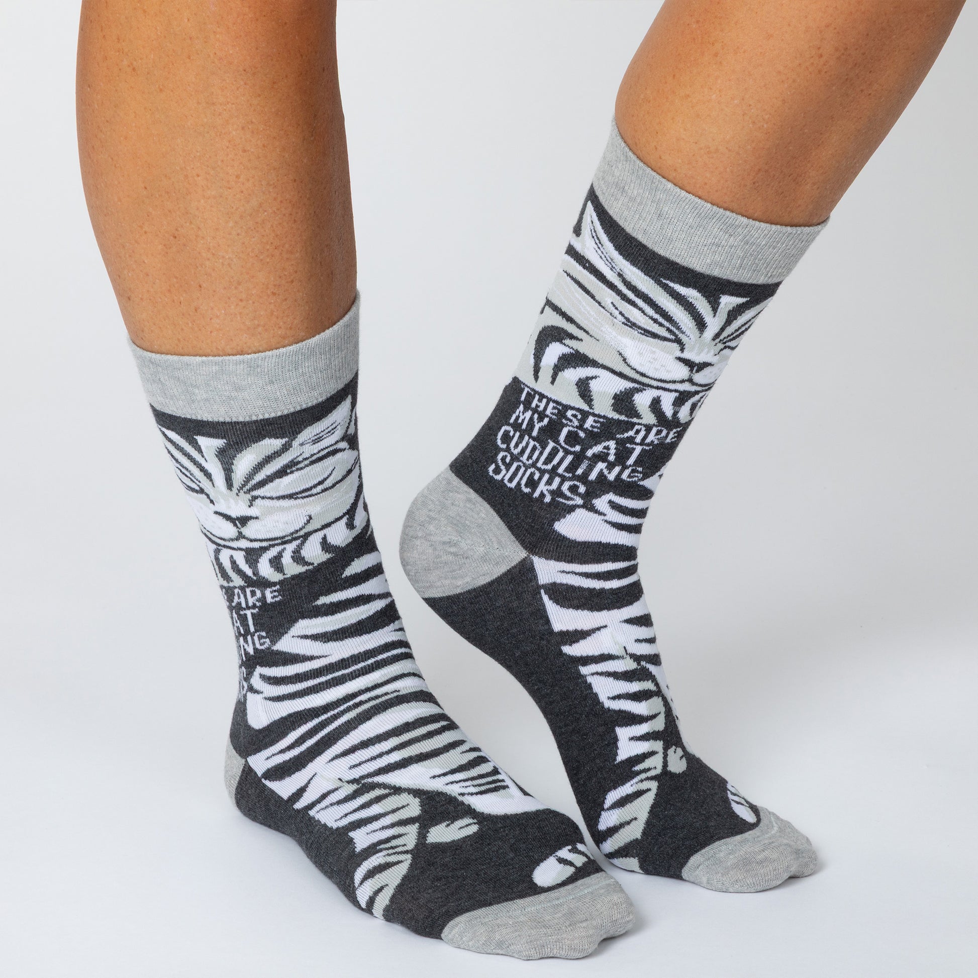 Gray and black striped cat socks with text about cat cuddling.