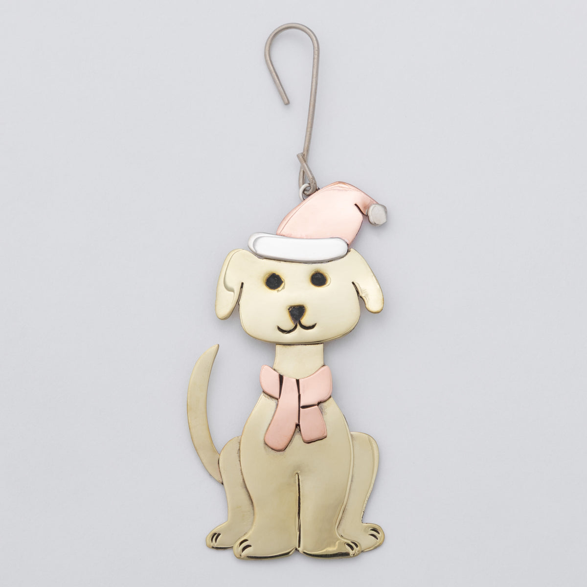 A dog-shaped hanging ornament or decoration in a cream color, wearing a pink Santa hat and a pink bow tie, shown against a plain light gray background.