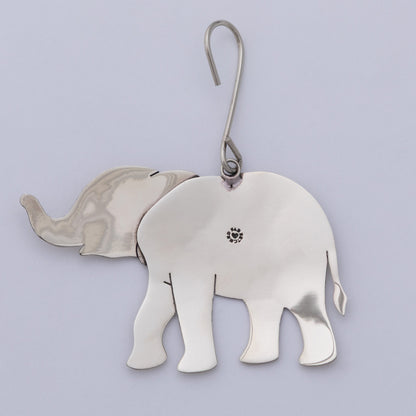 A polished silver elephant-shaped ornament with a curved metal hook at the top, shown against a light lavender background.