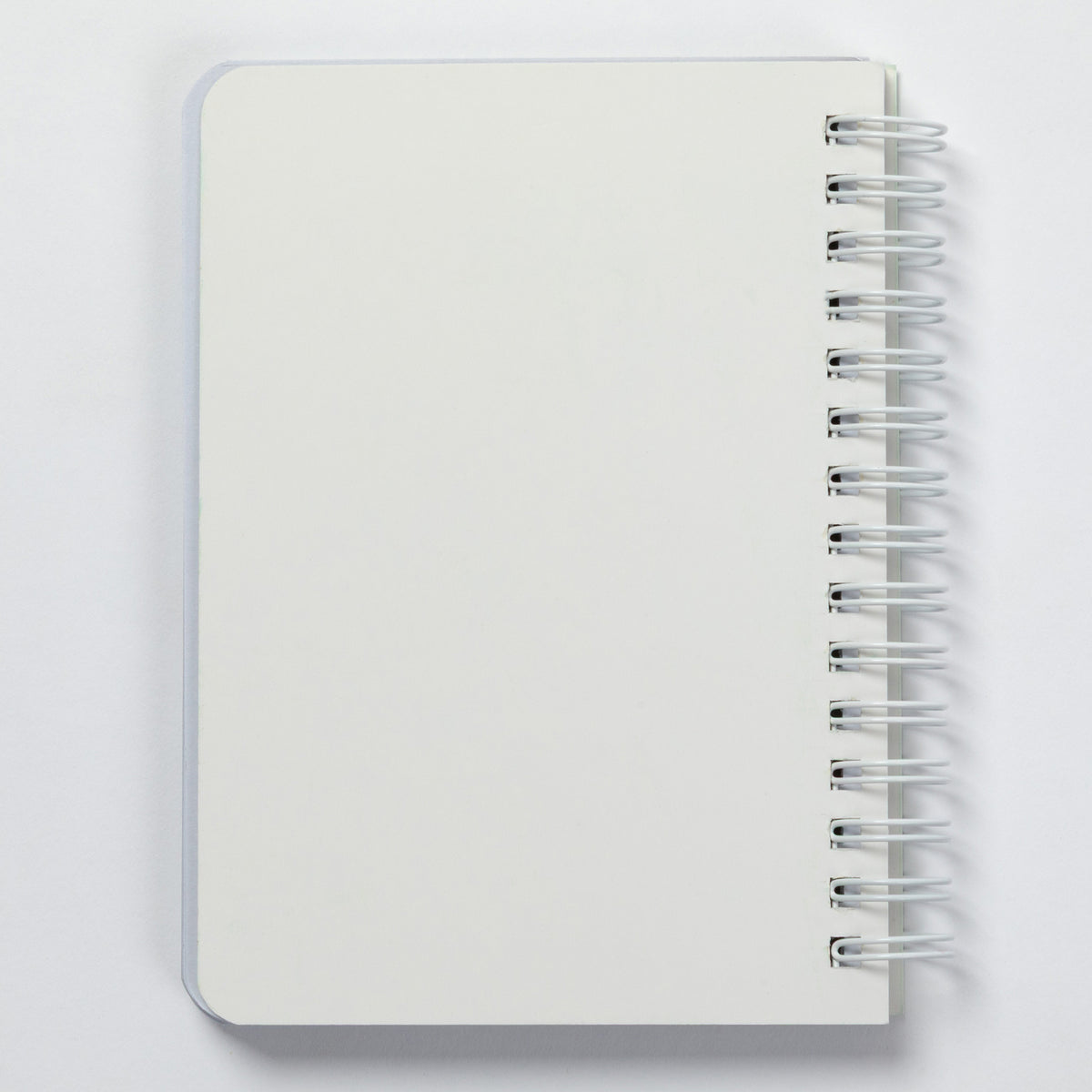 A blank white spiral-bound notebook with a silver wire binding, shown from a top-down perspective on a light gray background.