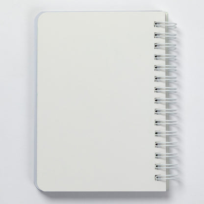 A blank white spiral-bound notebook with a silver wire binding, shown from a top-down perspective on a light gray background.