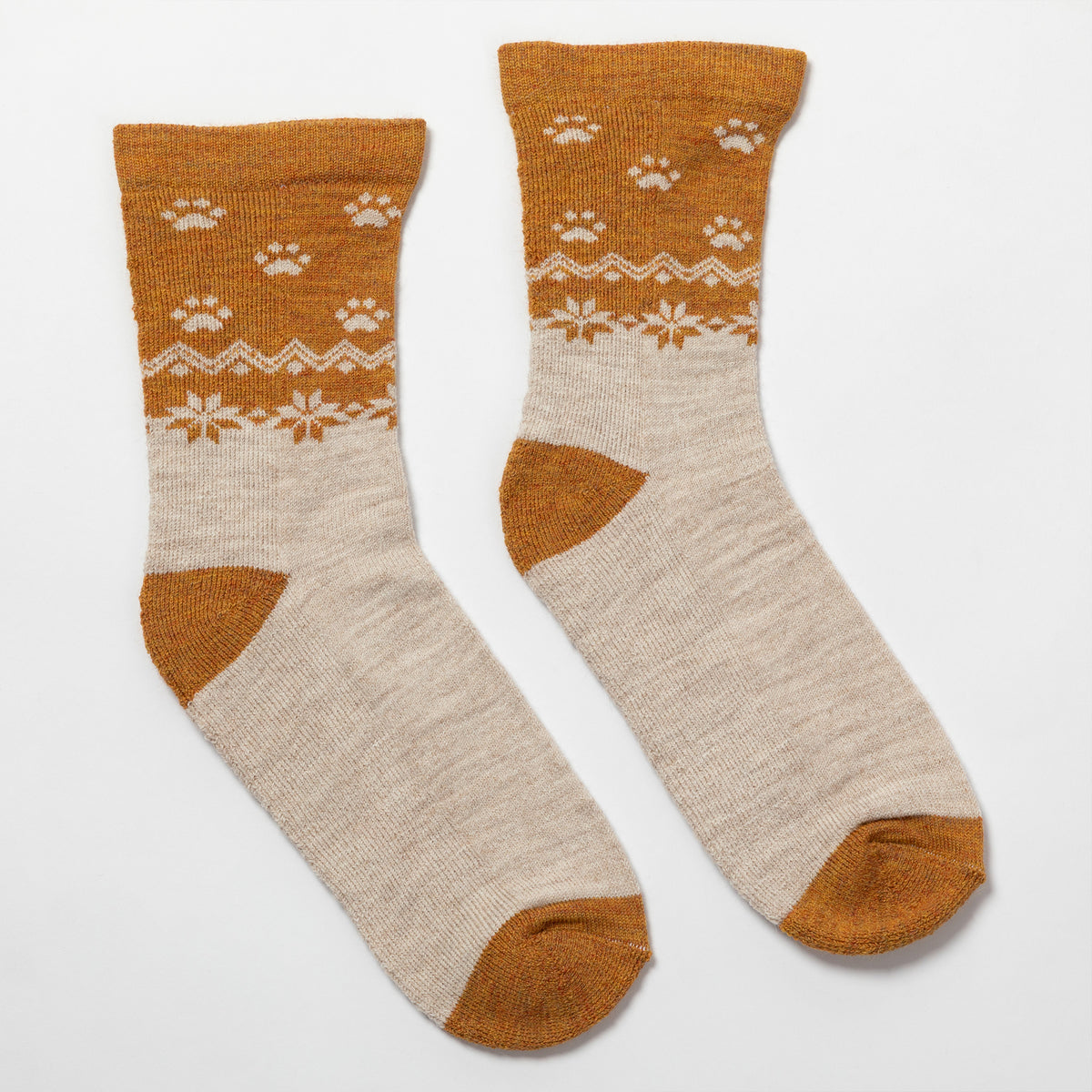 A pair of crew socks with a warm brown and cream knit pattern featuring paw prints and snowflake motifs, displayed on a clean white background.