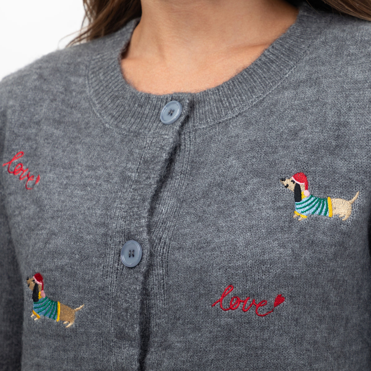 Close-up of a gray knit cardigan sweater with embroidered dachshunds wearing striped sweaters and red 'love' script text on the chest.