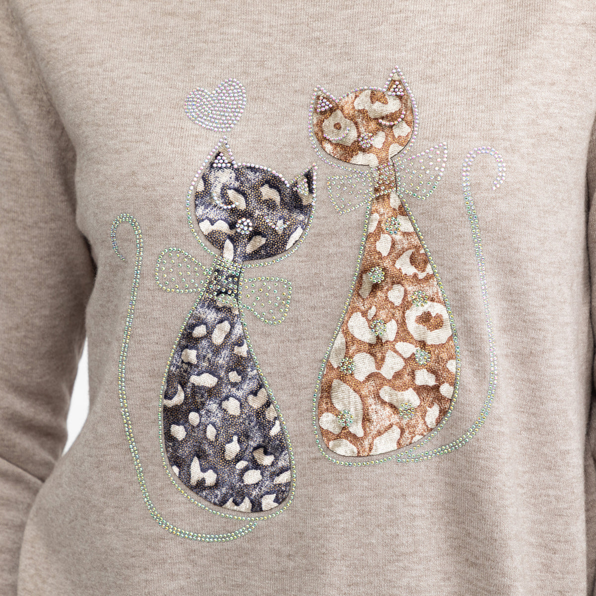 A close-up of a light heather gray sweatshirt featuring a graphic of two stylized cats adorned with rhinestone patterns and bows.