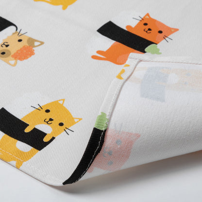 A close-up of a white dish towel, featuring a playful print of cartoon cats wrapped in black sushi rolls. The fabric is folded to show the texture and the reverse side with a subtle pastel pattern.