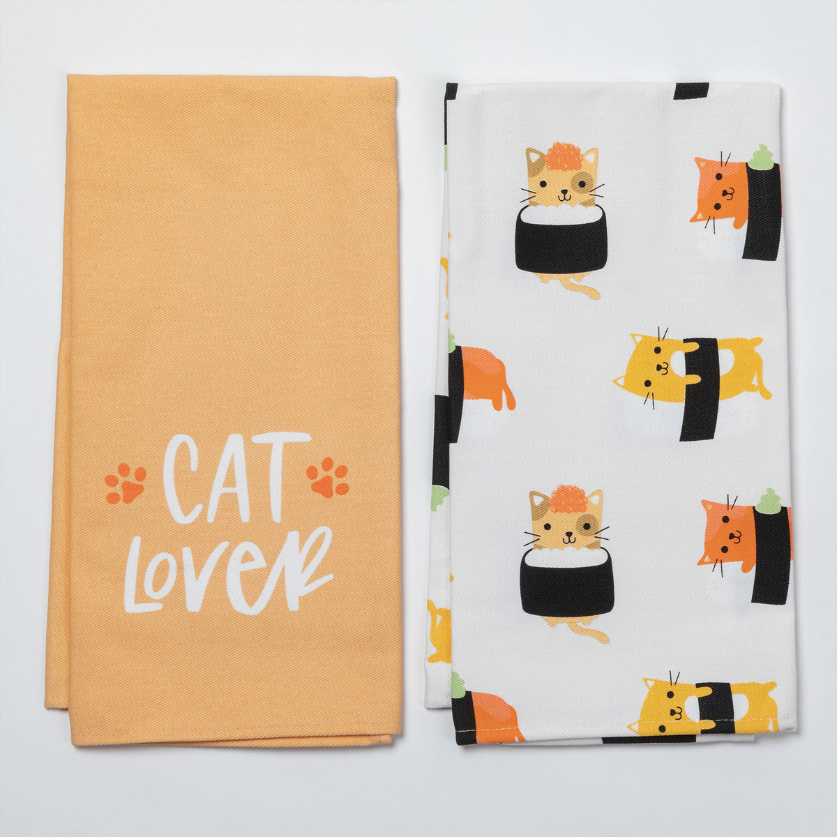 Two folded fabric kitchen towels on a light gray background. The left towel is a warm peach color with the words 'CAT LOVER' in white script and small orange paw prints.