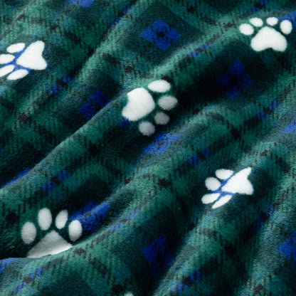 A close-up of a plush fleece blanket with a green and blue plaid pattern and white paw print motifs.