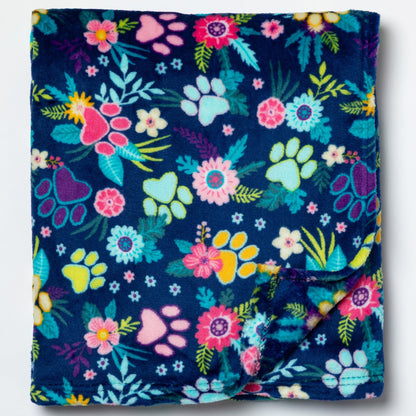 Floral and paw print patterned blanket on a white background