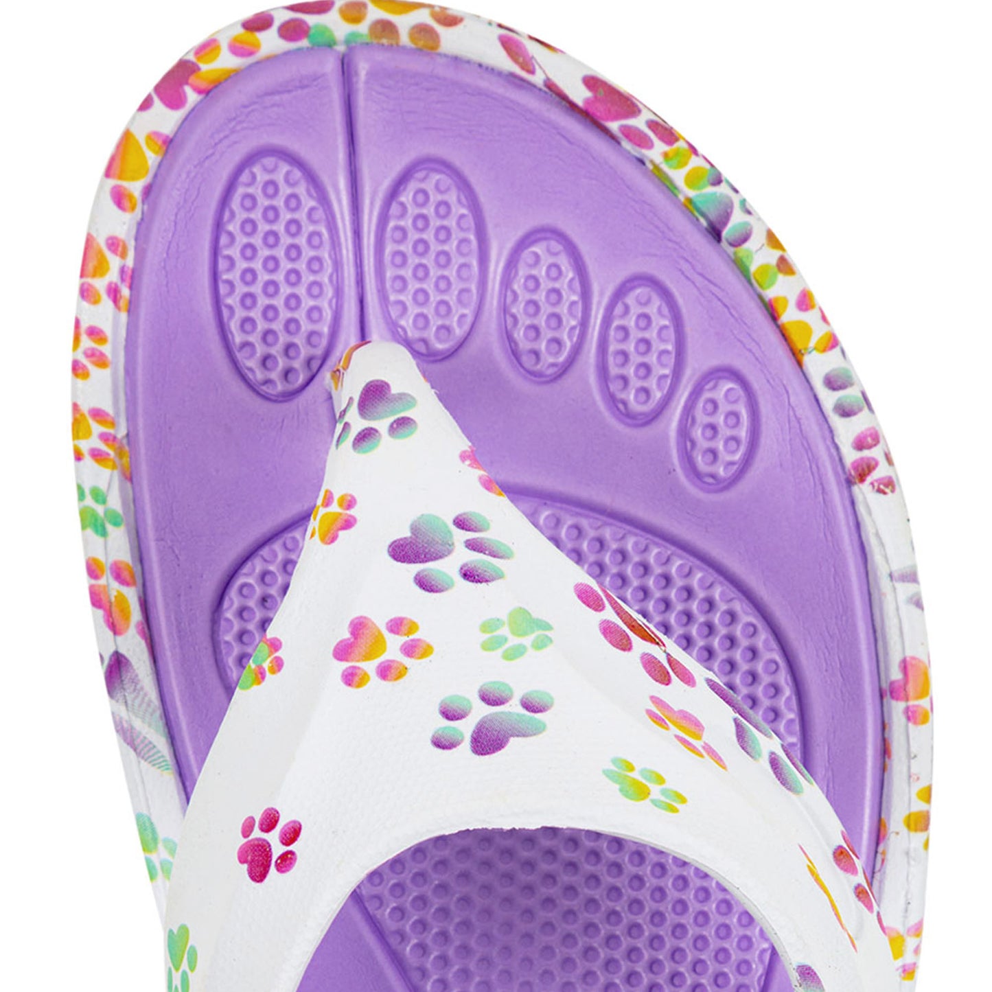 Textured purple insole of a rainbow ombre paw print flip flop, against a white background.