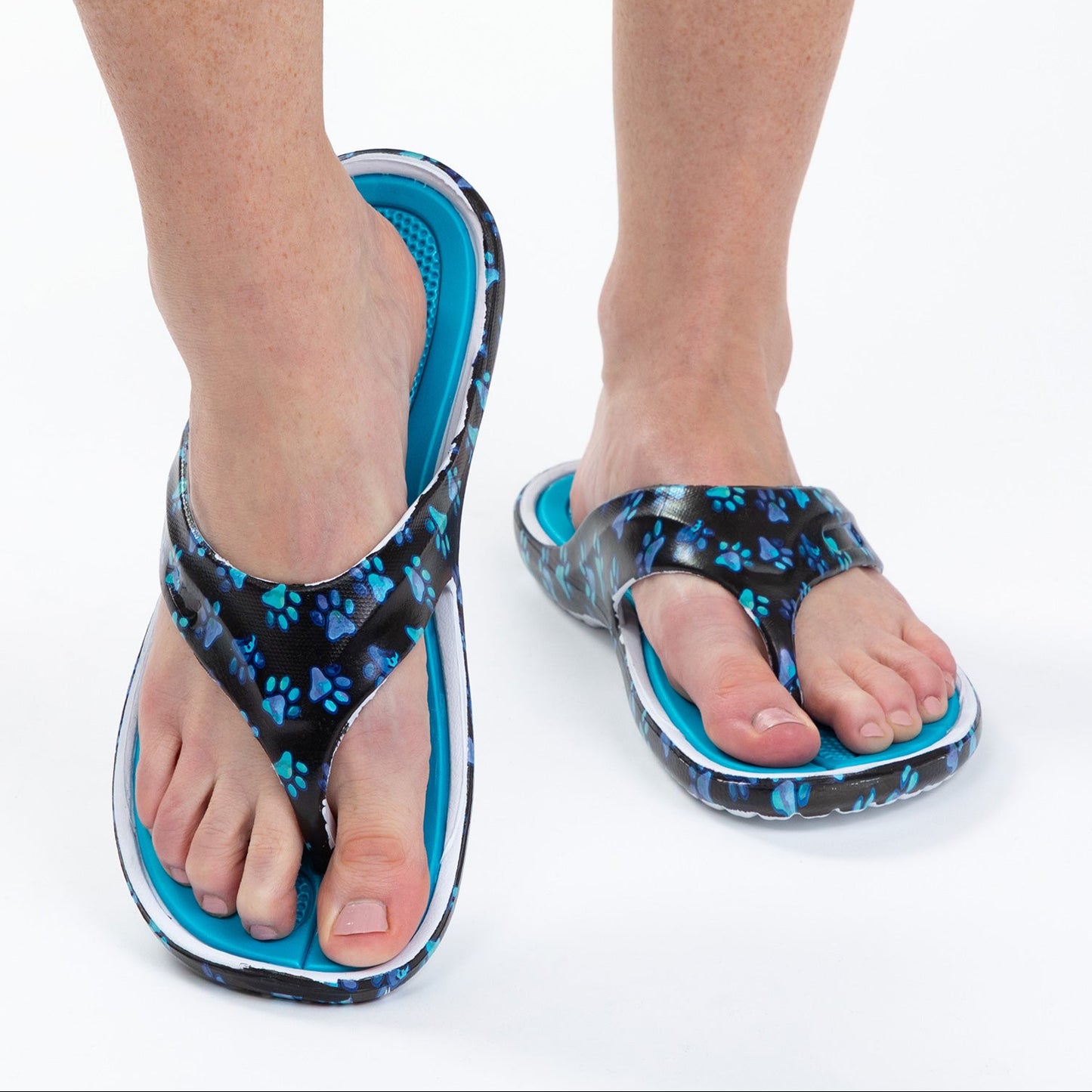 Blue paw print flip-flops worn by a person on a white background