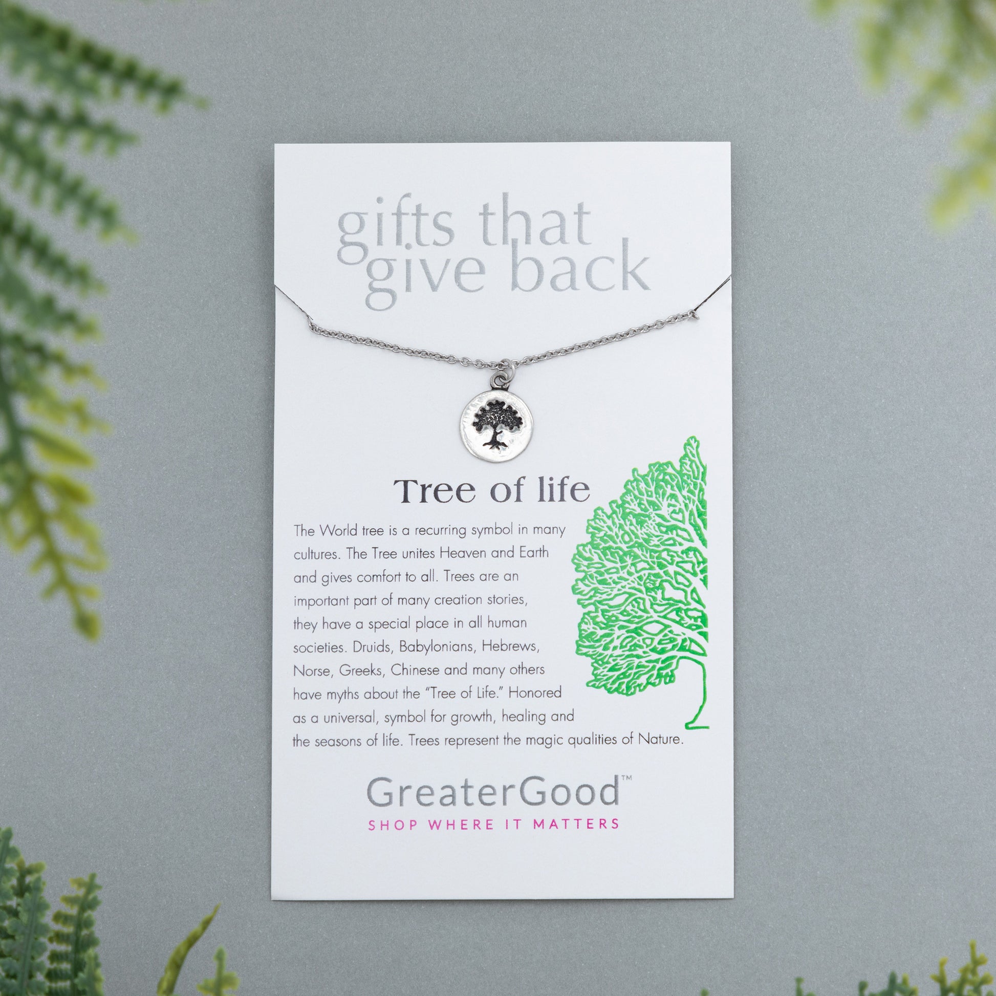 Necklace with 'Tree of Life' pendant on a GreaterGood branded card with greenery in the background