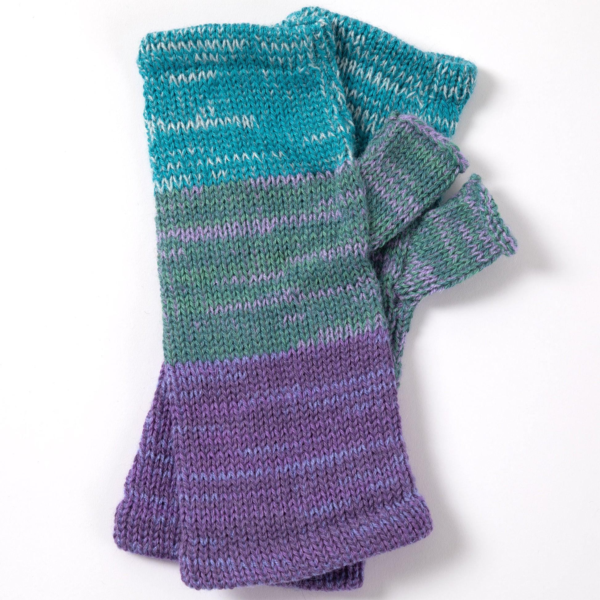 a pair of alpaca fingerless mittens in shades of blue, green, and purple made from alpaca wool on a white background