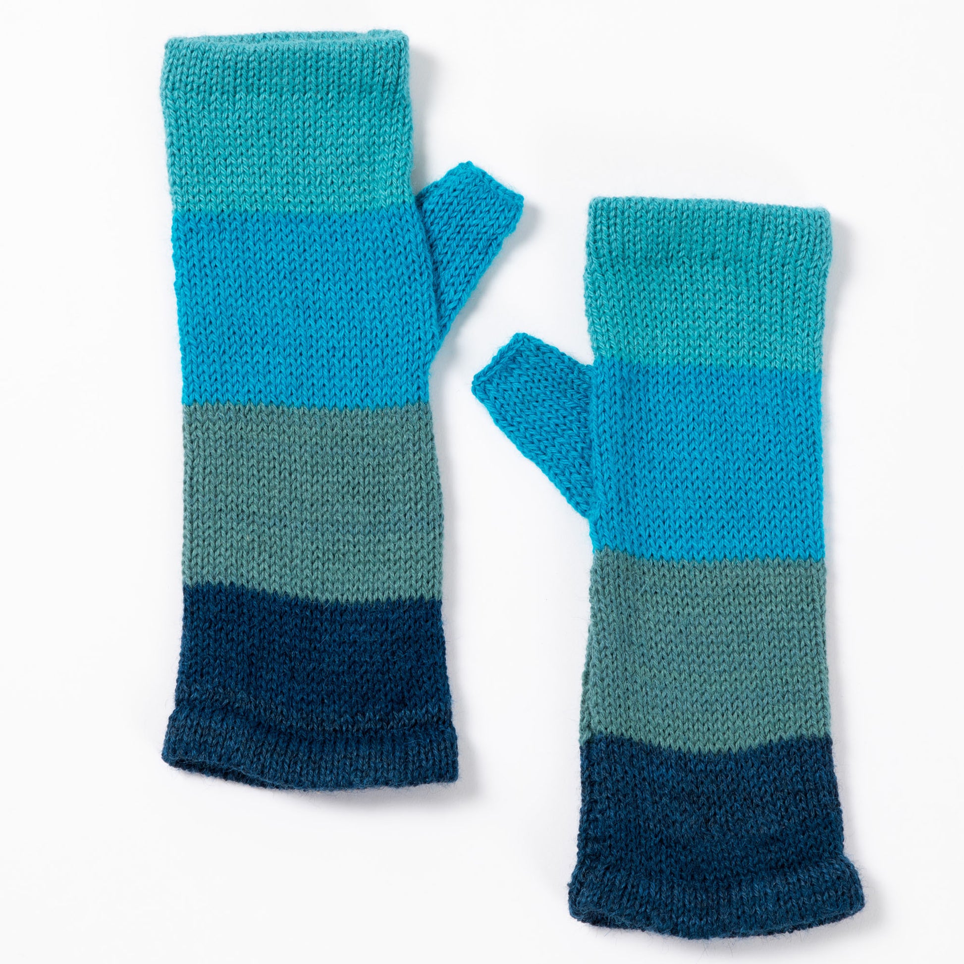 a pair of alpaca fingerless mittens in shades of blue made from alpaca wool on a white background