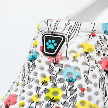 Close up of a clog with floral pattern and paw print design on a white background