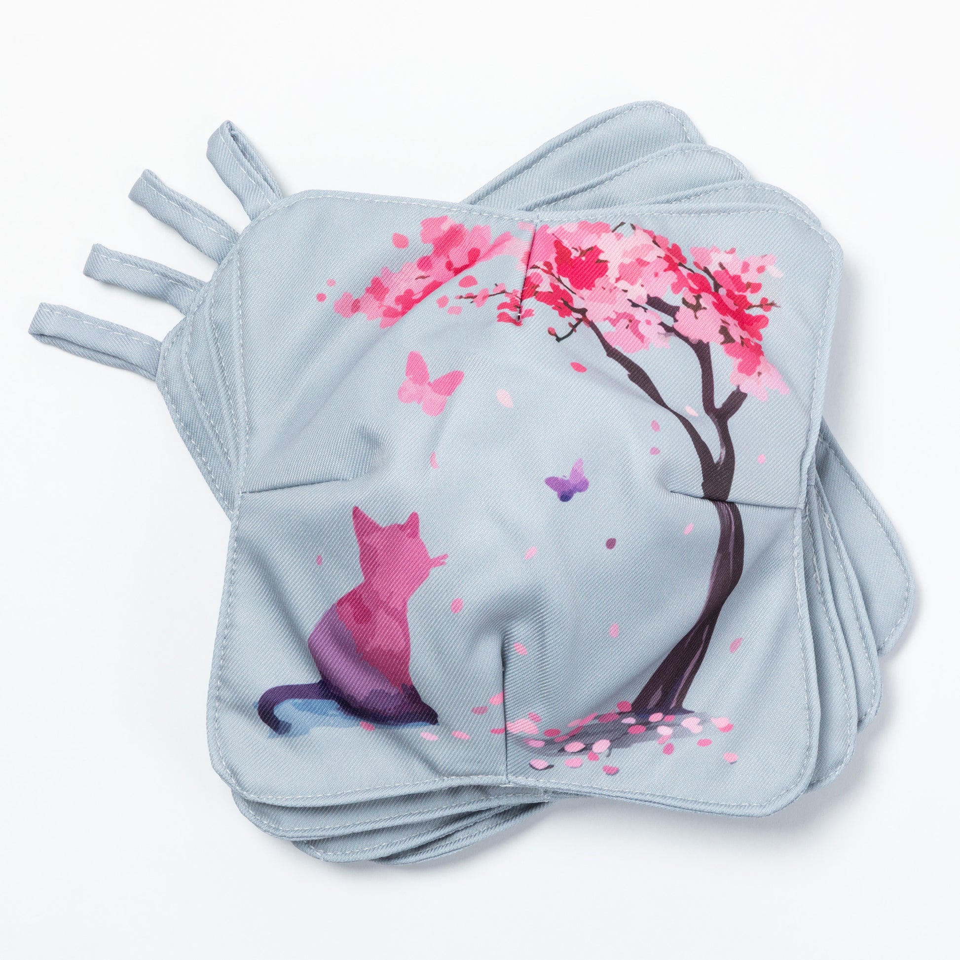 A set of four bowl cozies with various patterns, including a cat and cherry blossom print and floral design, cherry blossom and cat