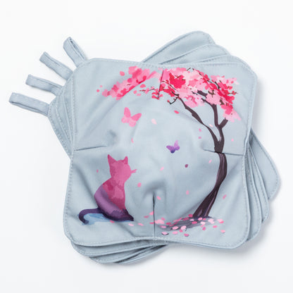 A set of four bowl cozies with various patterns, including a cat and cherry blossom print and floral design, cherry blossom and cat