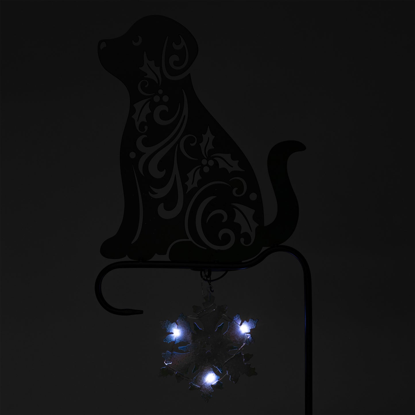Decorative metal dog silhouette with embedded lights on a black background